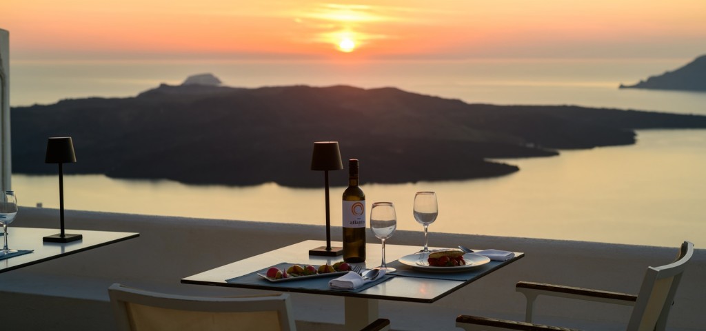 Sunset dining on a private terrace overlooking the caldera 