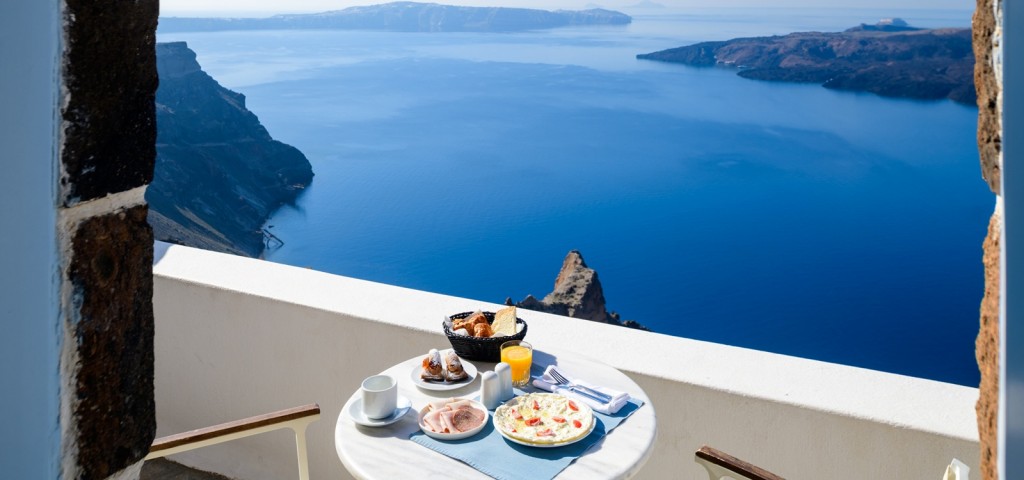 Panoramic Sunset Suite balcony overlooking the Santorini caldera at breakfast